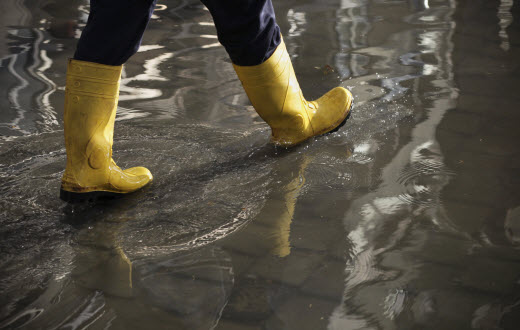 Rain boots walking along a flooded floor
