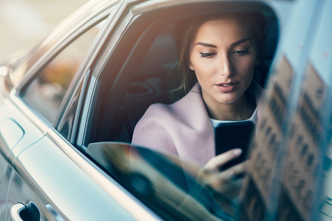 woman using phone in car