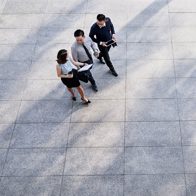 three business people walking across courtyard