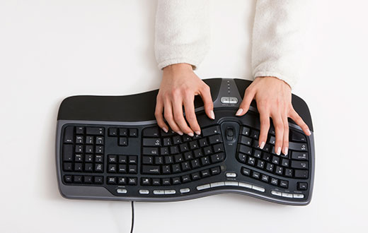 Person typing on ergonomic keyboard