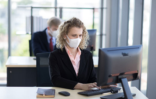 woman in facemask at desk