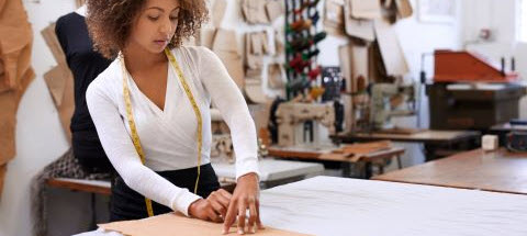 woman measuring material to sew