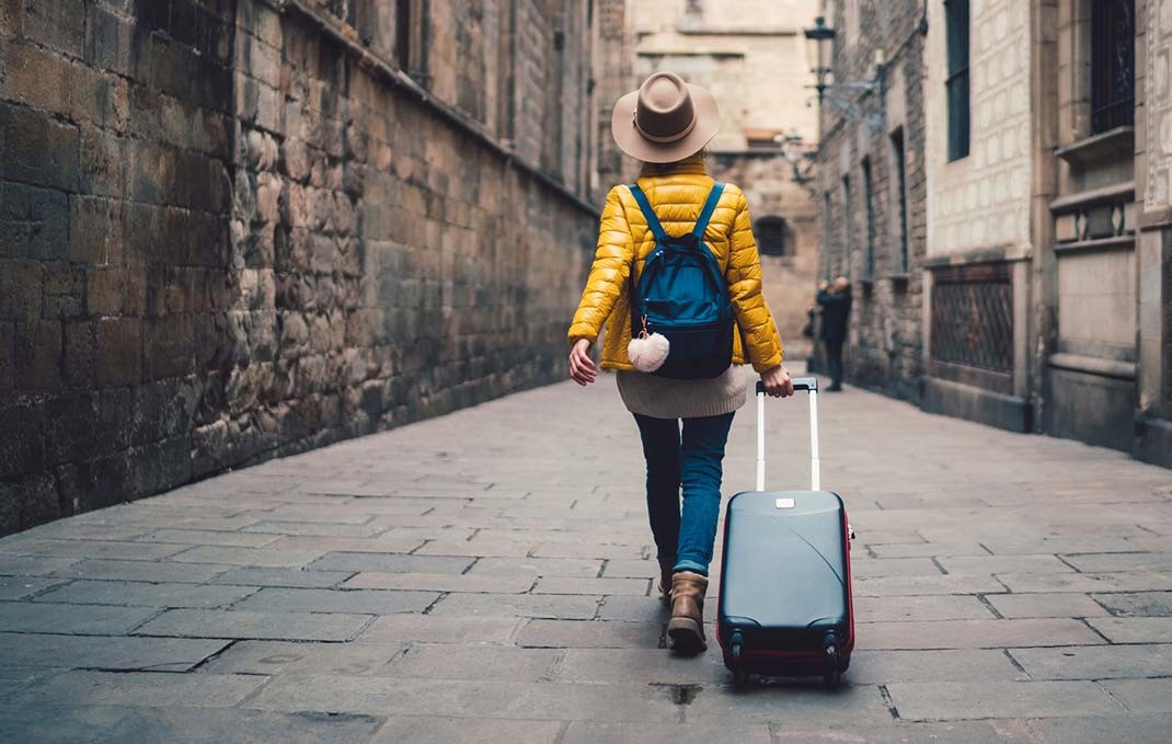 yellow jacket woman travel with suitcase