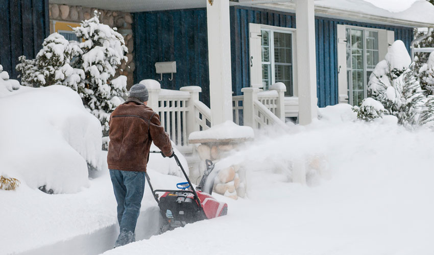 A man plowing his walkway after a snow storm