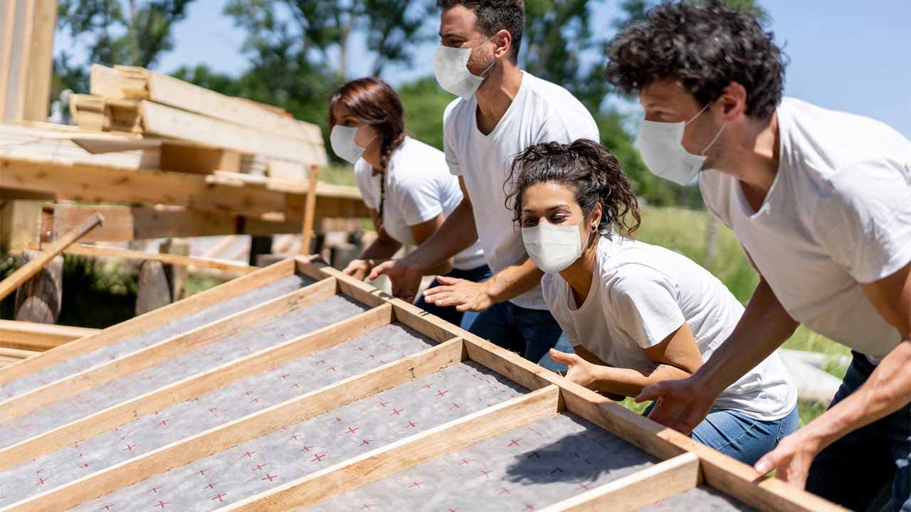 volunteers in facemasks building house