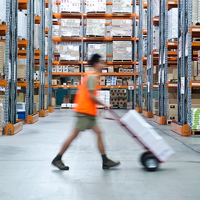 worker pushing hand cart in warehouse