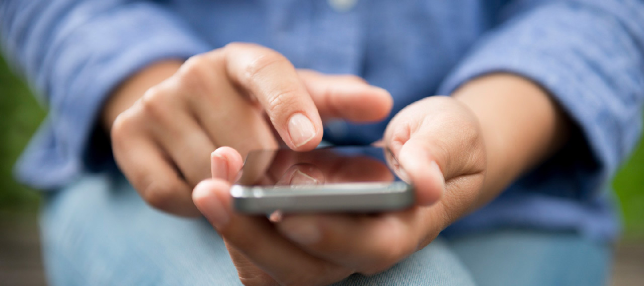 blue shirt woman using phone