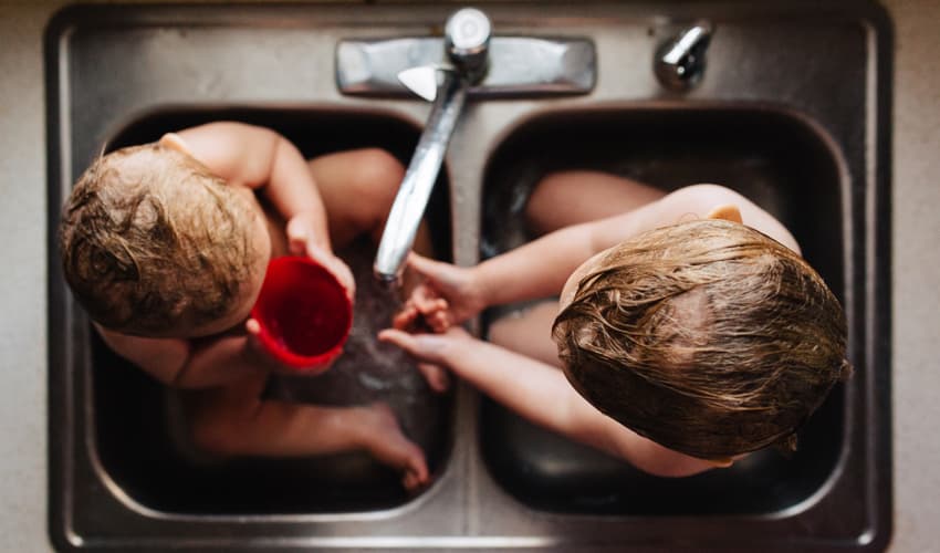 children taking a bath in sink