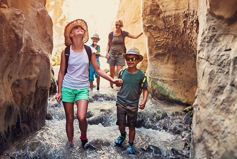 family hiking through a river