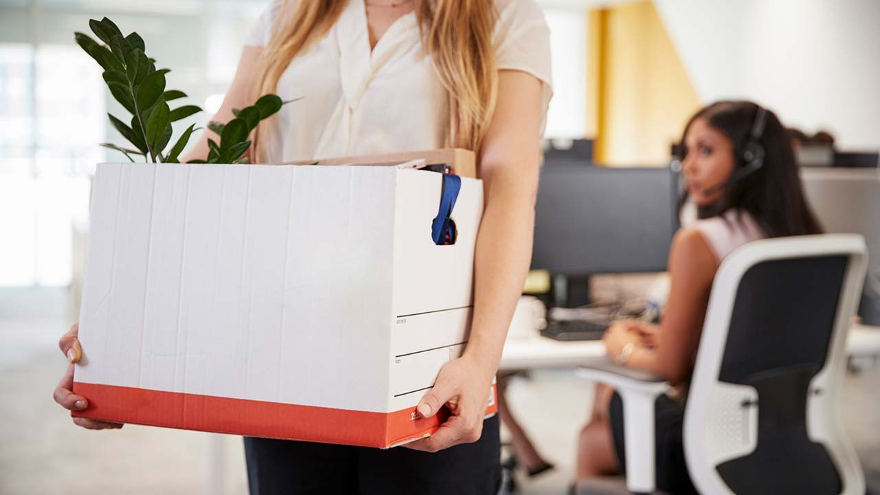 employée licenciée tenant une boîte d'effets personnels dans un bureau