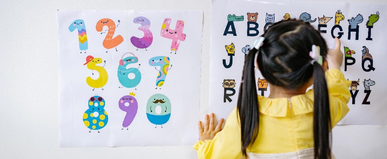 girl learning alphabets and numbers