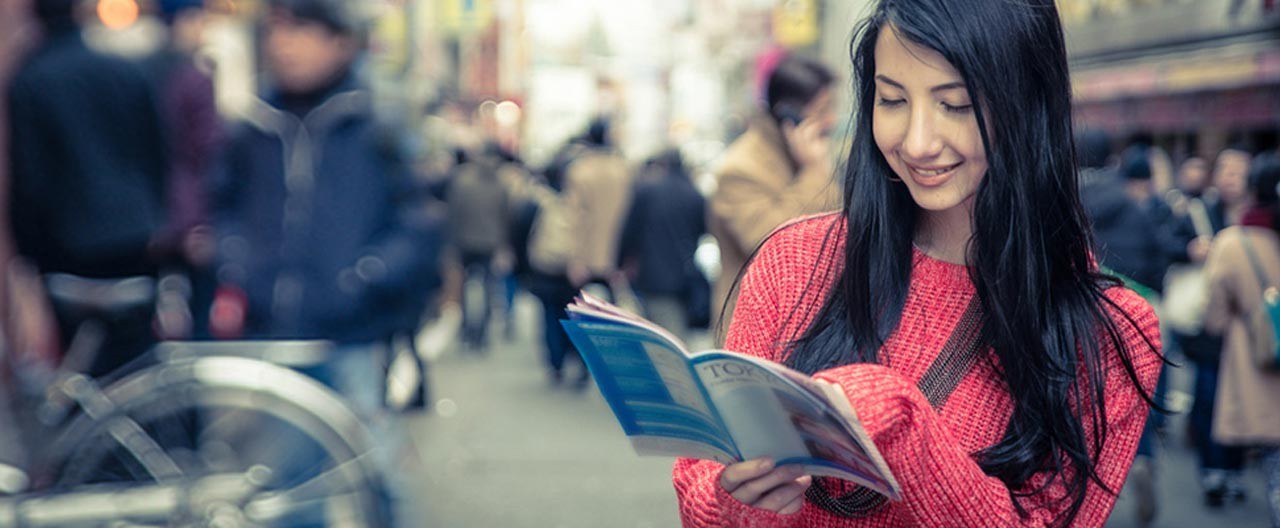 girl reading tokyo guide for tourist