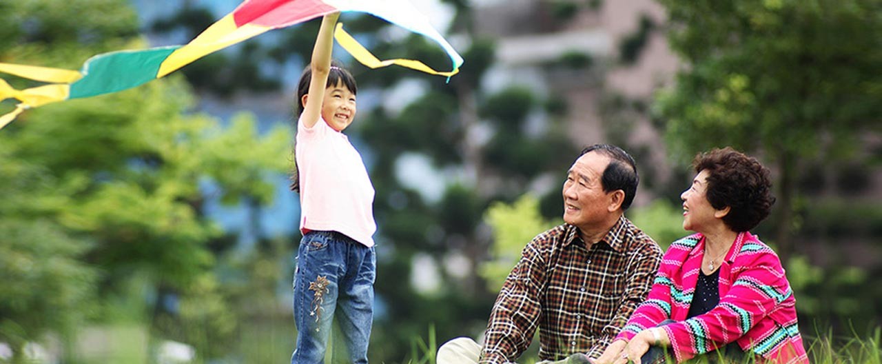 grandparents with granddaughter flying kite