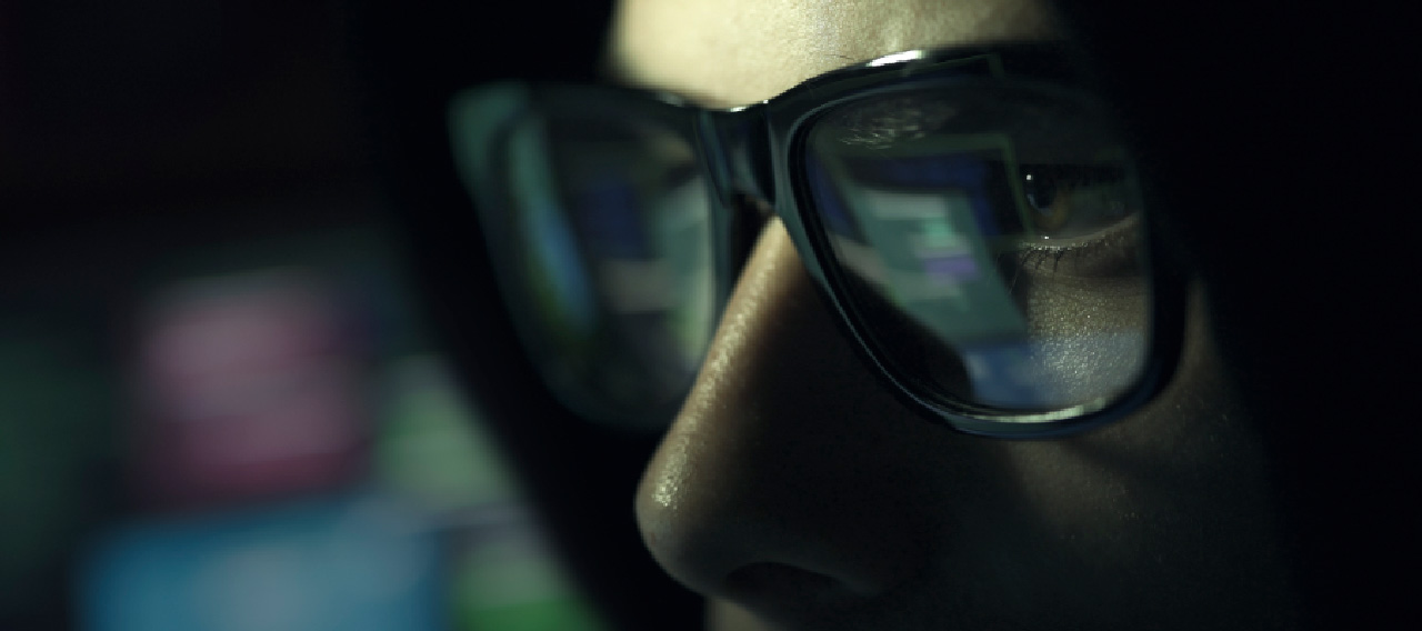 man wearing glasses closeup dark background