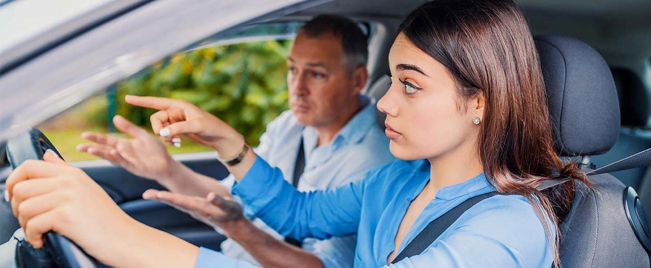 woman taking driving lessons from instructor
