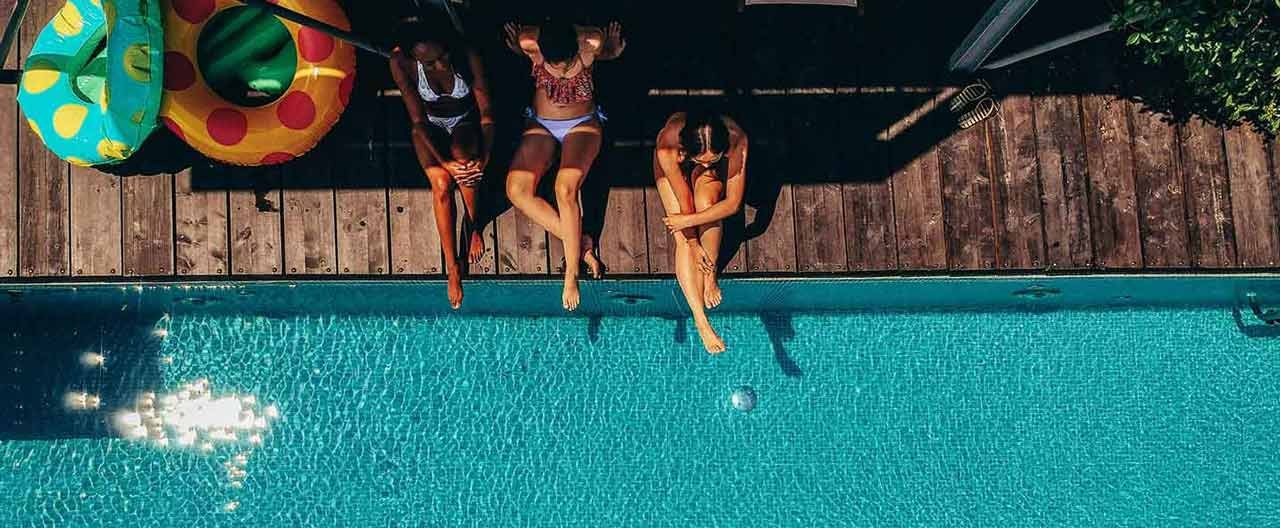 women sitting next to the pool