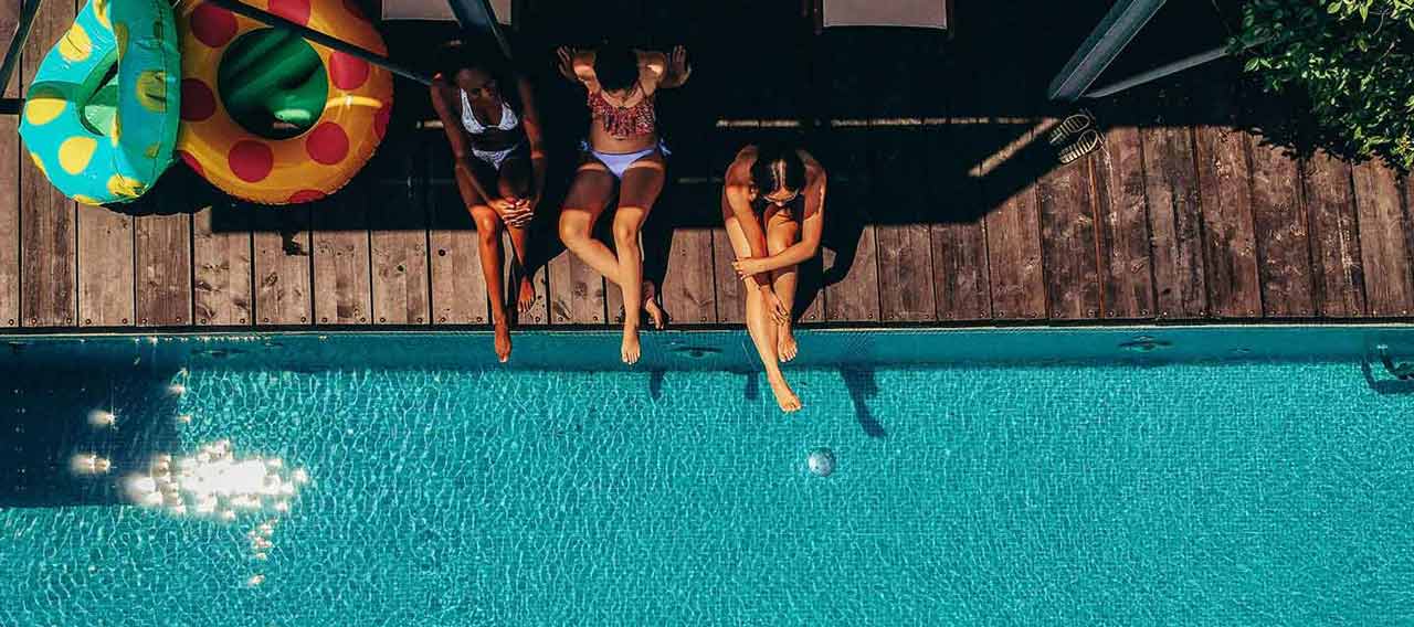 women sitting next to the pool