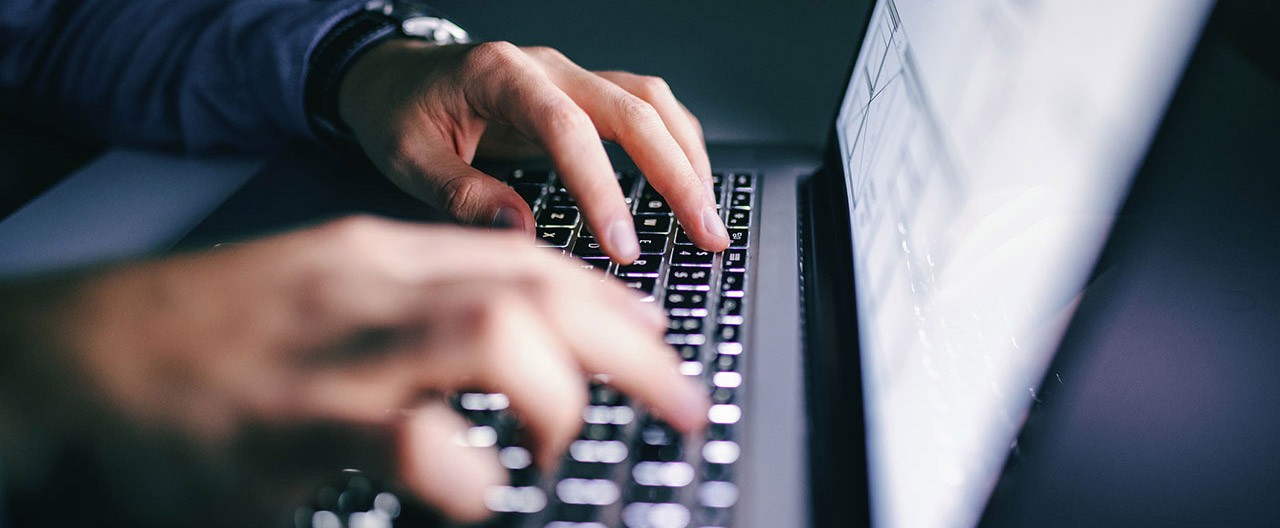 man typing on laptop