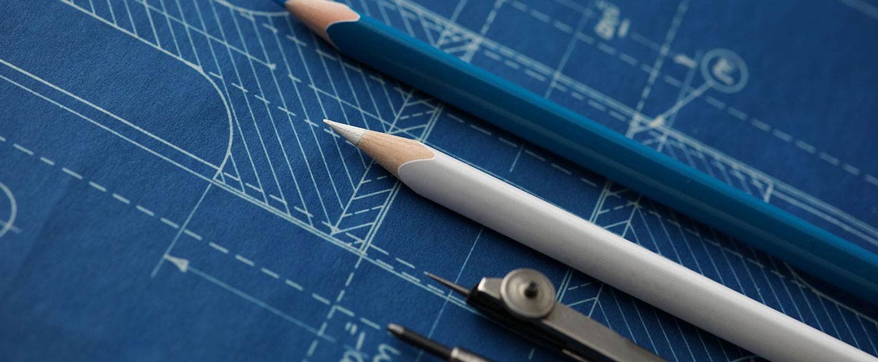 drawing tools lying over blueprint paper