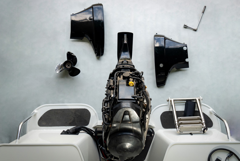 Repairing engines on aluminum boats , the technician is removing the boat parts to make the paint