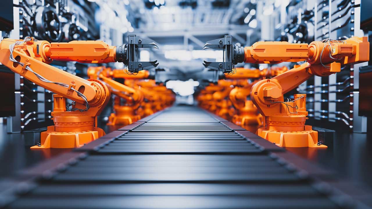 bras robotisés le long d'une chaîne de montage dans une usine moderne
