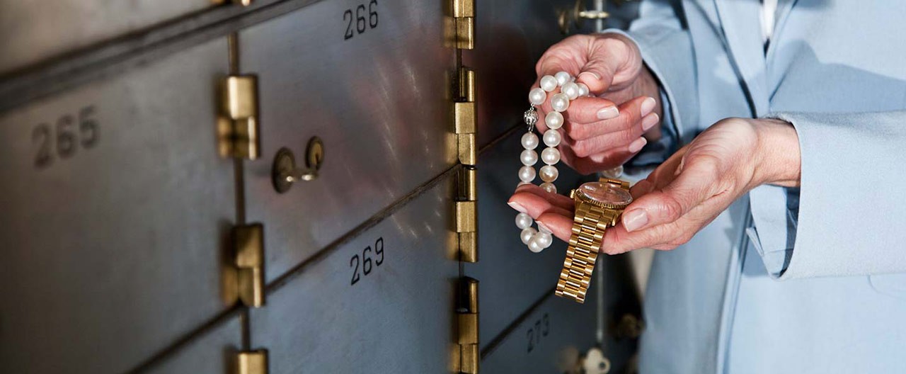 woman putting away jewelry in safe