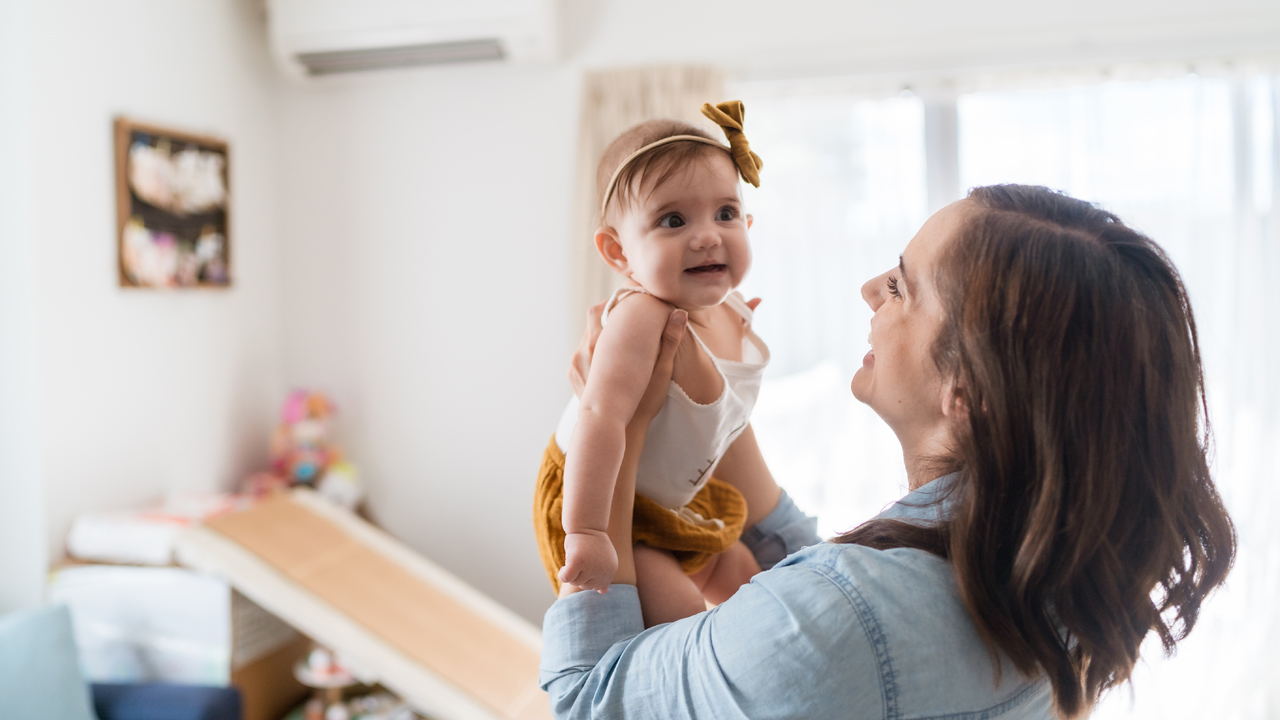 Mother holding daughter in the air