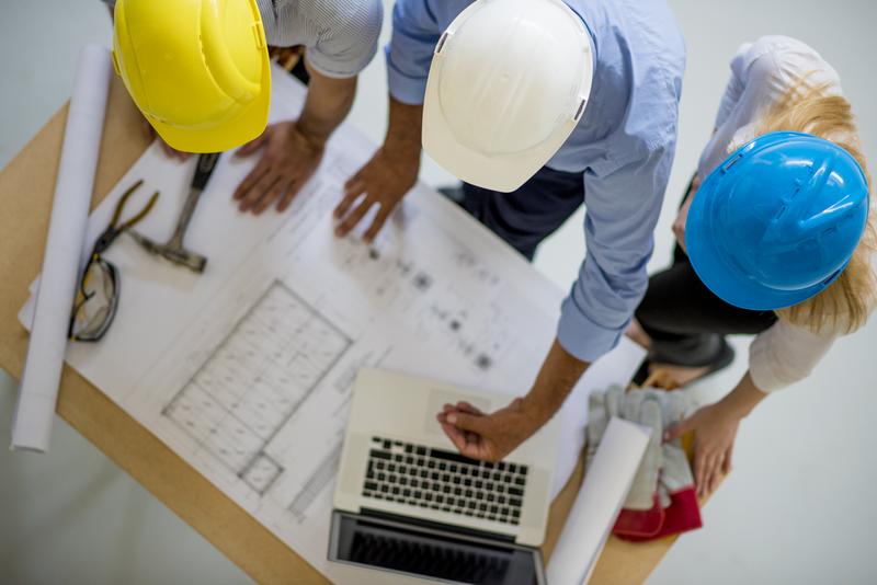 construction risk engineers reviewing blueprints