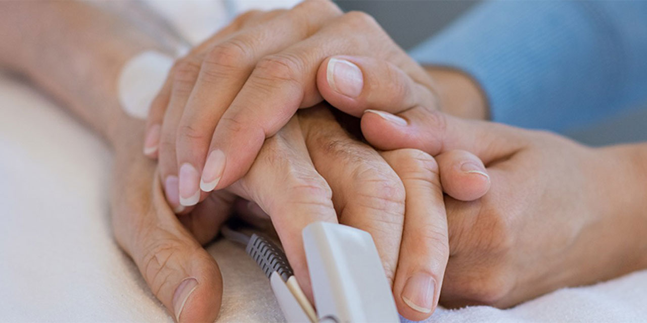 holding the hand of a hospitalized patient